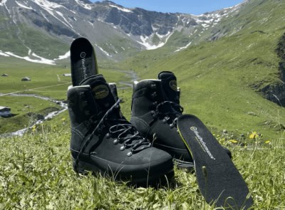 Semelles chauffantes dans des chaussures de randonnée dans une prairie de montagne