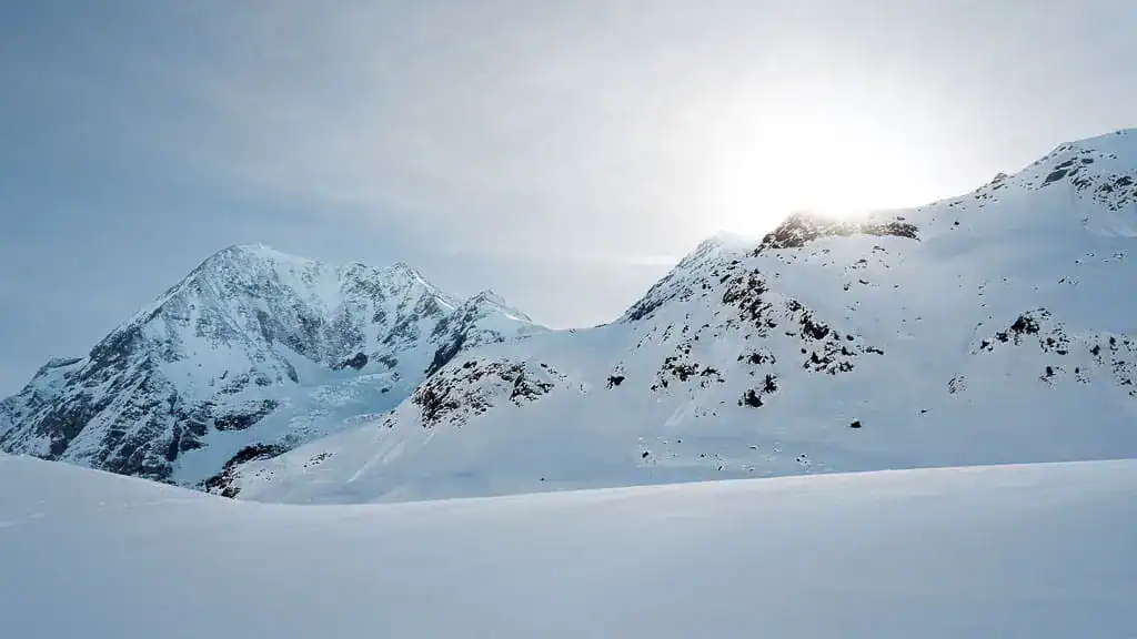 Verschneite Berglandschaft als Winterkulisse für beheizte Kleidung und Handschuhe